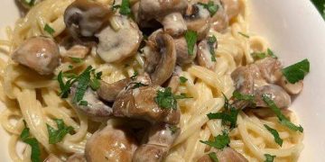 Spaghetti mit gebratenen Champignons in cremiger Rahmsoße